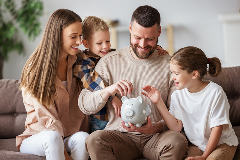 family putting coins in piggy bank