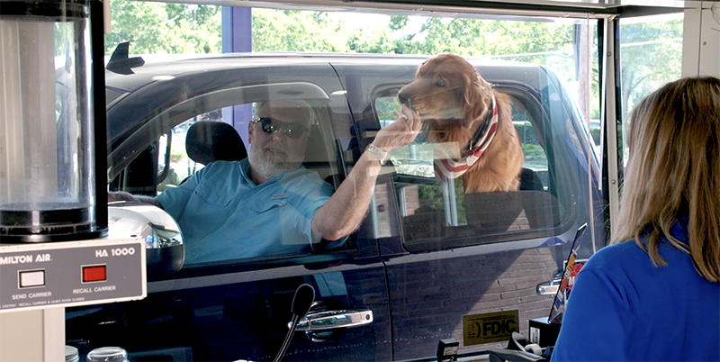 man with a dog in the bank